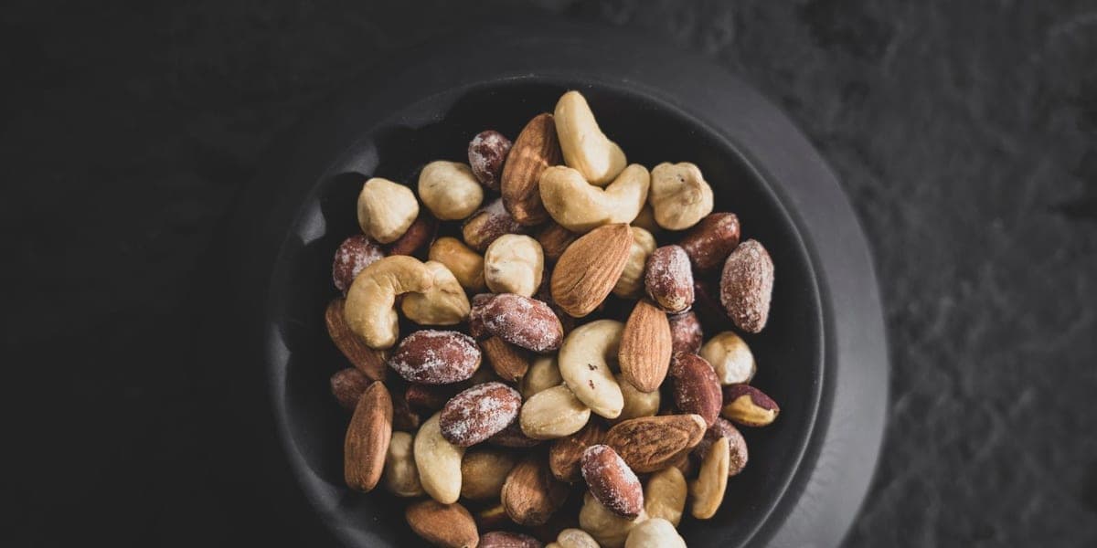 Mixed almonds, cashews and hazelnuts in a black bowl